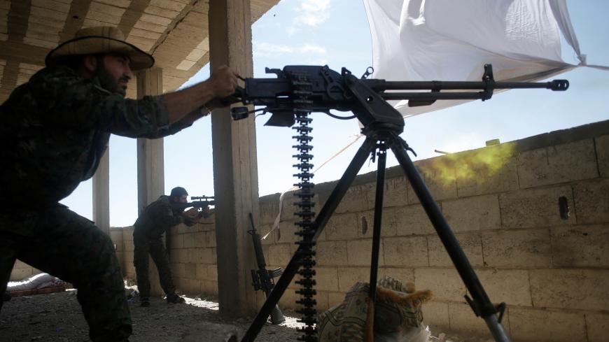 A Kurdish fighter from the People's Protection Units (YPG) fires heavy machine-gun at Islamic State militants in Raqqa, Syria June 21, 2017. REUTERS/Goran Tomasevic - RC13836C2800