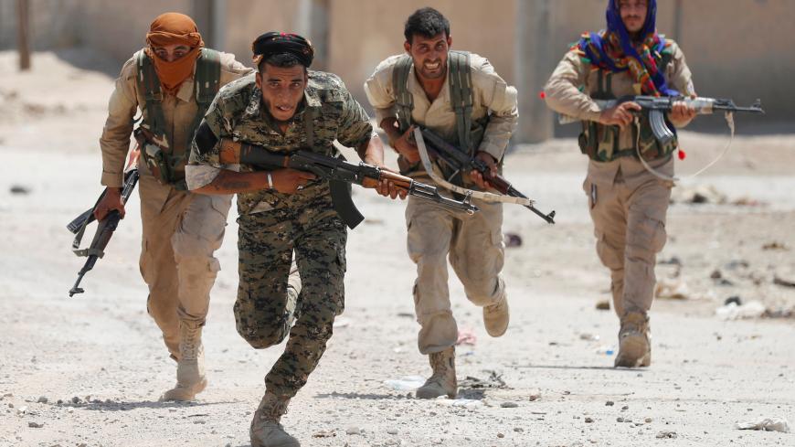 Kurdish fighters from the People's Protection Units (YPG) run across a street in Raqqa, Syria July 3, 2017. REUTERS/Goran Tomasevic     TPX IMAGES OF THE DAY - RC1F9D39A050