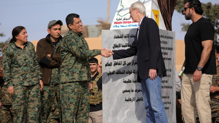 Mazloum Kobani, SDF's commander in chief, shakes hands with the advisor for the US Department of State in northern Syria William Robak, at al-Omar oil field in Deir Al Zor, Syria March 23, 2019. REUTERS/Rodi Said - RC142AE67C90