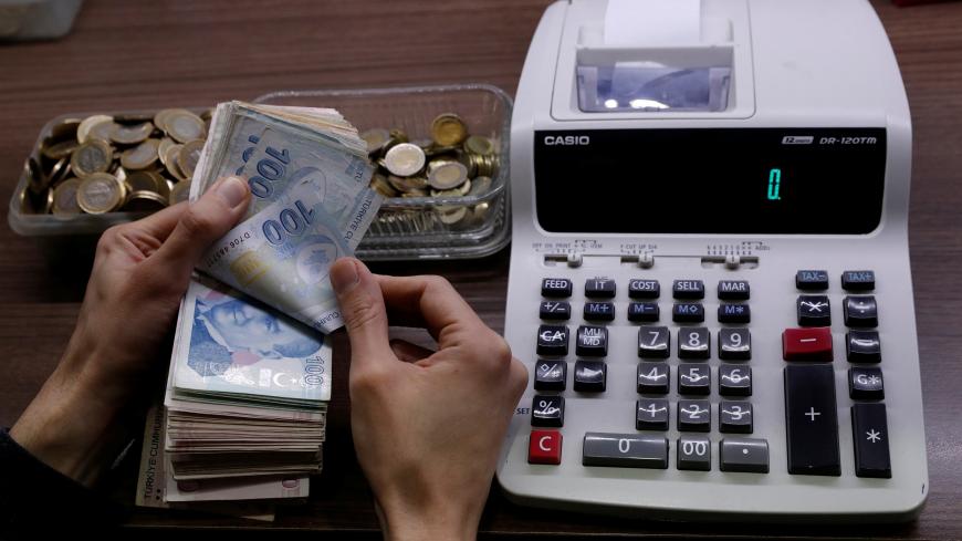 A merchant counts Turkish lira banknotes at the Grand Bazaar in Istanbul, Turkey, March 29, 2019. REUTERS/Murad Sezer - RC1275079610