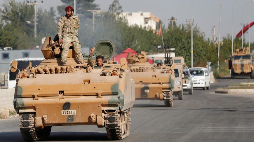 Members of Syrian National Army, known as Free Syrian Army, drive in an armored vehicle in the Turkish border town of Ceylanpinar in Sanliurfa province, Turkey, October 11, 2019. REUTERS/Murad Sezer - RC1E596B3770