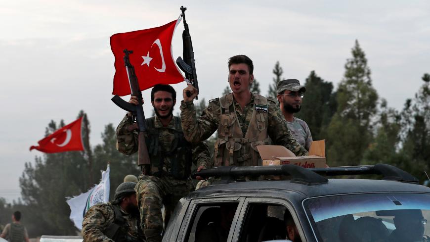 Turkey-backed Syrian rebel fighters drive on top of a truck to cross into Syria, near the border town of Akcakale in Sanliurfa province, Turkey, October 17, 2019. REUTERS/Murad Sezer - RC11C9239EE0