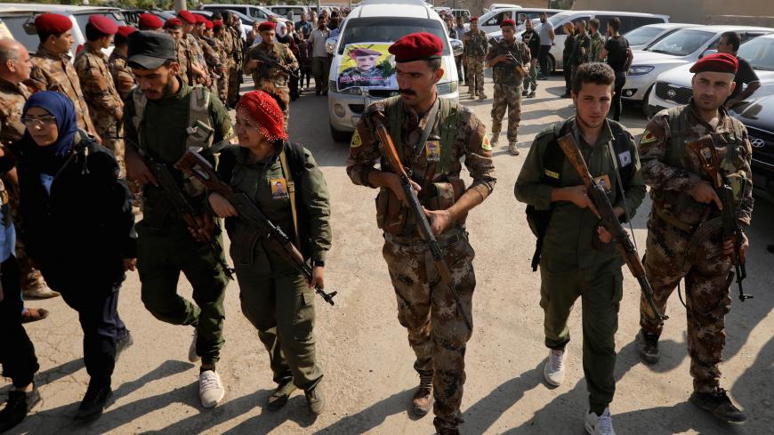 Fighters of Syrian Democratic Forces (SDF) take part in the funeral procession of Kurdish fighters who were killed during clashes in the northeastern Syrian town of Ras al-Ain, in the town of Qamishli, Syria October 22, 2019. REUTERS/Muhammad Hamed - RC1405293AB0