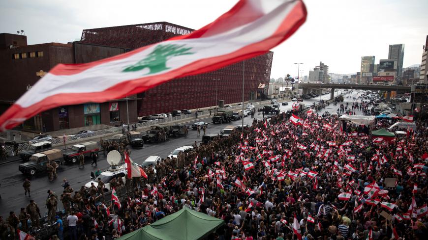 Demonstrators stand next to Lebanese army soldiers during ongoing anti-government protests at a highway in Jal el-Dib, Lebanon, October 23, 2019. REUTERS/Alkis Konstantinidis - RC1C59F962A0