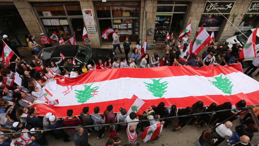 Demonstrators carry Lebanese flags during an anti-government protest in the mainly Druze town of Hasbaya, Lebanon October 25, 2019. REUTERS/Aziz Taher - RC1D8675FAA0