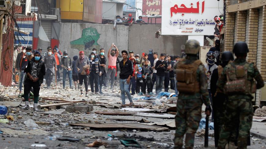 Iraqi demonstrators are seen near Iraqi security forces during ongoing anti-government protests, in Baghdad, Iraq November 25, 2019. REUTERS/Khalid al-Mousily - RC2GID9PZRKP