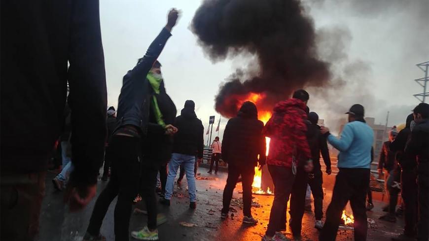 Iranian protesters gather around a fire during a demonstration against an increase in gasoline prices in the capital Tehran, on November 16, 2019. - One person was killed and others injured in protests across Iran, hours after a surprise decision to increase petrol prices by 50 percent for the first 60 litres and 300 percent for anything above that each month, and impose rationing. Authorities said the move was aimed at helping needy citizens, and expected to generate 300 trillion rials ($2.55 billion) per 
