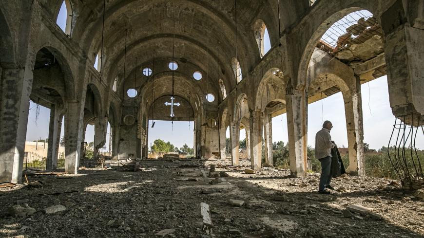 Sarkoun Selio, a 50-year-old Assyrian Christian Syrian and one of the few Assyrians still living there, walks in the ruins of the Assyrian Church of the Virgin Mary, which was previously destroyed by Islamic State (IS) group fighters, in the village of Tal Nasri south of the town of Tal Tamr in Syria's northeastern Hasakah province on November 15, 2019. - The few Assyrian Christians who escaped the Islamic State group invasion in 2015, and did not choose to emigrate, now anxiously watch the advance of Turki