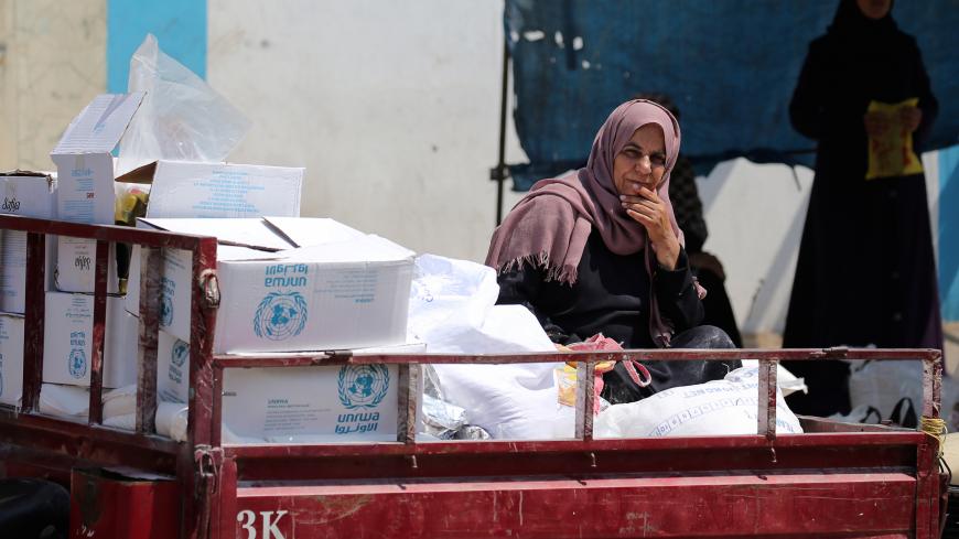 A Palestinian woman sits in a motorised vehicle loaded with aid, outside a distribution center run by the United Nations Relief and Works Agency (UNRWA), in Khan Younis in the southern Gaza Strip September 4, 2018. REUTERS/Ibraheem Abu Mustafa - RC1A87FA4580