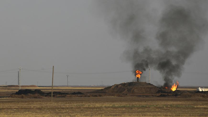 Smoke rises from an oil field in Al-Rmelan, Qamshli province November 11, 2013. With a string of military gains across northeastern Syria, a Kurdish militia is solidifying a geographic and political presence in the war-torn country, posing a dilemma for regional powers. Long oppressed under Syrian President Bashar al-Assad and his father before him, Kurds view the civil war as an opportunity to gain the kind of autonomy enjoyed by their ethnic kin in neighbouring Iraq. Picture taken November 11, 2013.  REUT