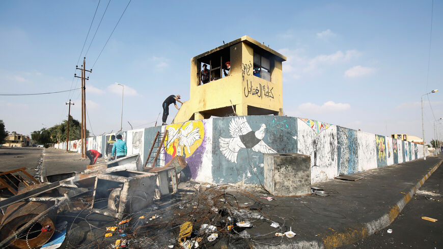 An Iraqi demonstrator climbs to Iraqi security forces check room during ongoing anti-government protests in Nassiriya, Iraq December 4, 2019. Picture taken December 4, 2019. REUTERS/Alaa al-Marjani - RC2MPD9W9BIX