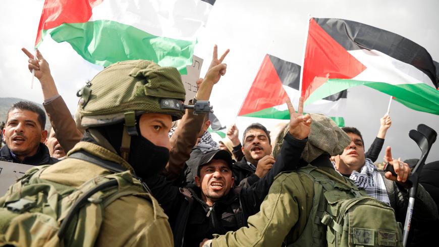 Palestinian demonstrators gesture in front of Israeli forces during a protest against the U.S. president Donald Trump’s Middle East peace plan, in Jordan Valley in the Israeli-occupied West Bank January 29, 2020. REUTERS/Raneen Sawafta - RC2PPE9PRZMB