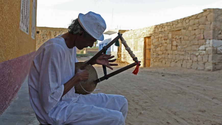 A man plays music on a traditional musical instrument in the Nubian village of Adindan near Aswan, south of Egypt, September 30, 2015.  For half a century, Egypt's Nubians have patiently lobbied the government in Cairo for a return to their homelands on the banks of the Nile, desperate to reclaim territory their ancestors first cultivated 3,000 years ago. Yet all their efforts to gain political influence have brought next to nothing. In Egypt's incoming parliament, which will be finalised after a second rou