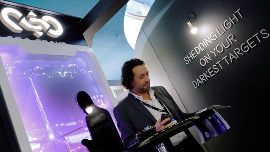 A man reads at a stand of the NSO Group Technologies, an Israeli technology firm known for its Pegasus spyware enabling the remote surveillance of smartphones, at the annual European Police Congress in Berlin, Germany, February 4, 2020. REUTERS/Hannibal Hanschke - RC2MTE9GIMJ9