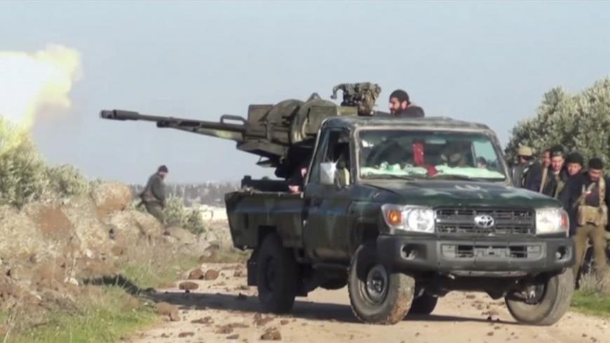 A still image taken from a video obtained by Reuters and shot on March 2, 2020, shows Syrian army soldiers firing a weapon as they advance on the town of Kfar Nabl, Syria. Reuters TV/via REUTERS - RC2DCF9FHZKZ