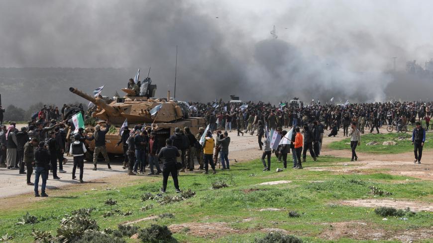 People hold Syrian opposition flags during a protest against an agreement on joint Russian and Turkish patrols, at M4 highway in Idlib province, Syria, March 15, 2020. REUTERS/Khalil Ashawi - RC2EKF9A7CNX