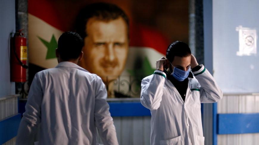 A health worker with a face mask walks inside a hospital, as hospitals enforce a series of measures to prevent the spread of the coronavirus disease (COVID-19), in Damascus, Syria March 19, 2020. REUTERS/Omar Sanadiki - RC20NF9CYGOY