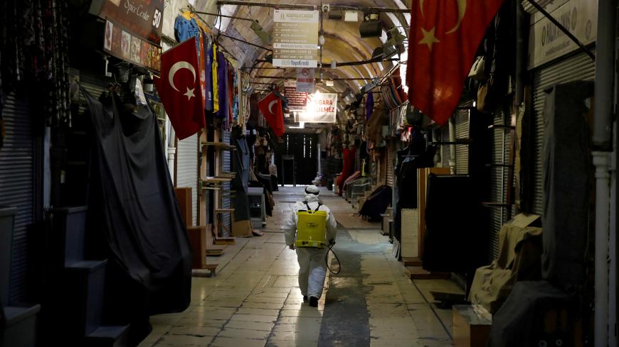 A worker in a protective suit sprays disinfectant at Grand Bazaar, known as the Covered Bazaar, to prevent the spread of coronavirus disease (COVID-19), in Istanbul, Turkey, March 25, 2020. REUTERS/Umit Bektas TPX IMAGES OF THE DAY - RC2YQF9U548J