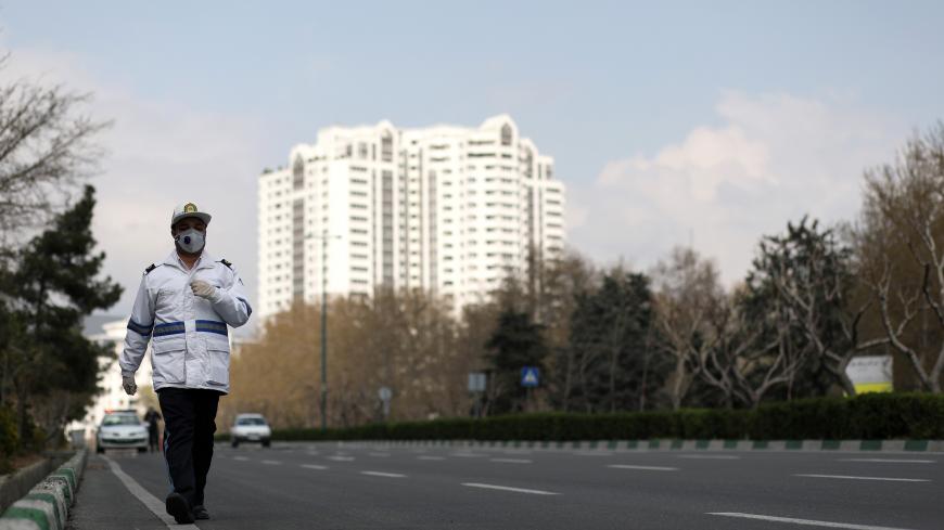 A traffic police officer wears a protective face mask and gloves, amid fear of coronavirus disease (COVID-19), as he walks in Tehran, Iran March 26, 2020. WANA (West Asia News Agency)/Ali Khara via REUTERS ATTENTION EDITORS - THIS PICTURE WAS PROVIDED BY A THIRD PARTY - RC2PRF9GFZAQ