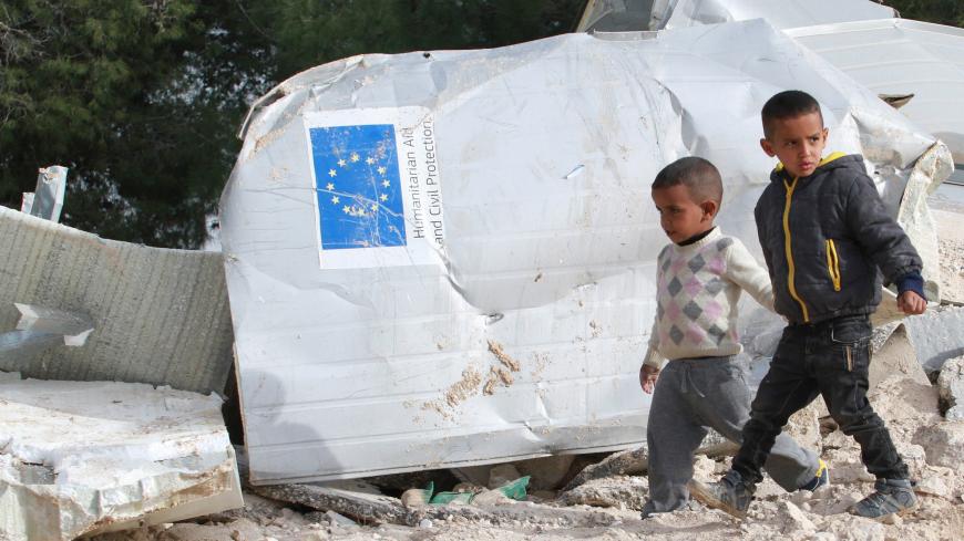 Palestinian boys walks past the remains of their family's dwelling, that was funded by the EU's humanitarian arm, after it was demolished by Israeli forces, near the West Bank village of Al-Eizariya, near east of Jerusalem January 21, 2016. In a development likely to further upset Europe, Israeli forces demolished six structures in the West Bank funded by the EU's humanitarian arm. The structures were dwellings and latrines for Bedouins living in an area known as E1 - a particularly sensitive zone between J
