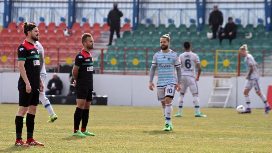 Amedspor players (L) stand still to protest Turkish Football Federation after the kick-off their Turkish Cup quarter final first leg soccer match against Fenerbahce in the Kurdish-dominated southeastern city of Diyarbakir, Turkey February 9, 2016. Two rival Turkish football teams stood defiantly behind a banner urging peace on Tuesday before playing a surreal quarter final match to an empty stadium in Turkey's conflict-ridden southeast following a ban on spectators for chanting political slogans. The confli