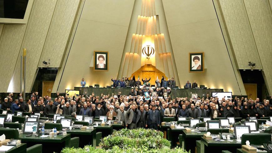 This handout picture provided by the Islamic Consultative Assembly News Agency (ICANA) on January 7, 2020 shows Iranian lawmakers raising their hands to vote during a parliamentary session in Tehran. - Iran's parliament passed a bill designating all US forces "terrorists" over the killing of a top Iranian military commander in a US strike last week. Under the newly adopted bill, all US forces and employees of the Pentagon and affiliated organisations, agents and commanders and those who ordered the "martyrd