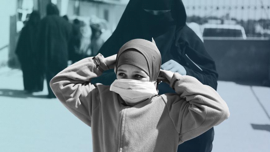 A Syrian woman sets a protective mask on a child's face after a lecture provided by staff from Turkey's Humanitarian Relief Foundation (IHH) to raise awareness about the novel coronavirus epidemic at a camp for the displaced in Kafr Lusin village, on the border with Turkey, in Syria's northwestern province of Idlib, on March 23, 2020. - Testing for the novel coronavirus is to start within days in northwest Syria, the World Health Organisation said, amid fears of a disaster if the pandemic reached overcrowde