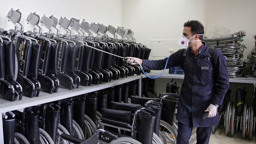 A member of the medical team sprays disinfectant to sanitize wheel chairs in Imam Reza's holy shrine, following the coronavirus outbreak, in Mashhad, Iran February 27, 2020. Picture taken February 27, 2020.  WANA (West Asia News Agency) via REUTERS ATTENTION EDITORS - THIS PICTURE WAS PROVIDED BY A THIRD PARTY - RC2FAF9KEZWN
