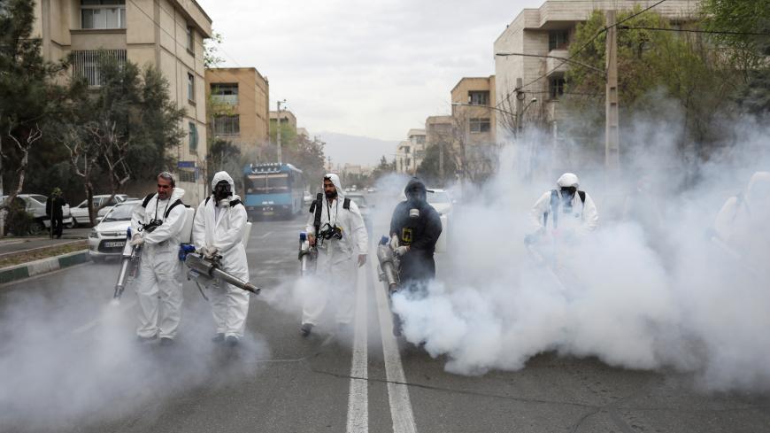 Members of firefighters wear protective face masks, amid fear of coronavirus disease (COVID-19), as they disinfect the streets, ahead of the Iranian New Year Nowruz, March 20, in Tehran, Iran March 18, 2020. Picture taken March 18, 2020. WANA (West Asia News Agency)/Ali Khara via REUTERS ATTENTION EDITORS - THIS PICTURE WAS PROVIDED BY A THIRD PARTY     TPX IMAGES OF THE DAY - RC23NF9FQH2G