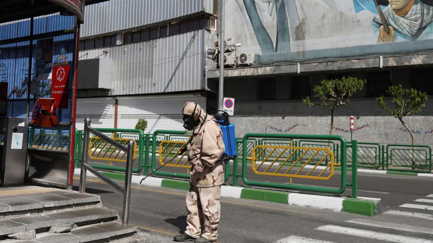 A volunteer from Basij forces wearing a protective suit and face mask sprays disinfectant as he sanitizes a bus station, amid the coronavirus disease (COVID-19) fears, in Tehran, Iran April 3, 2020. WANA (West Asia News Agency)/Ali Khara via REUTERS ATTENTION EDITORS - THIS PICTURE WAS PROVIDED BY A THIRD PARTY - RC2YWF9E0PWW