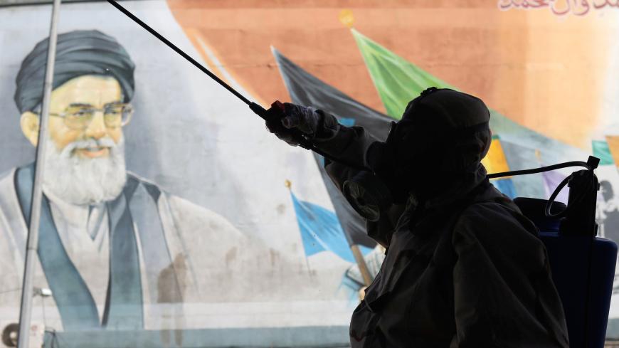 A volunteer from Basij forces wearing a protective suit and face mask sprays disinfectant as he sanitizes a bus station, amid the coronavirus disease (COVID-19) fears, in Tehran, Iran April 3, 2020. WANA (West Asia News Agency)/Ali Khara via REUTERS ATTENTION EDITORS - THIS PICTURE WAS PROVIDED BY A THIRD PARTY - RC2YWF9PA44V