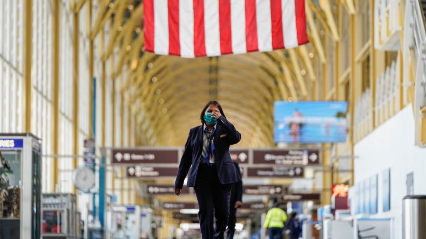 An airline employee walks through Reagan National Airport during the coronavirus disease (COVID-19) outbreak in Washington, U.S., April 5, 2020. REUTERS/Joshua Roberts - RC2KYF955PLJ