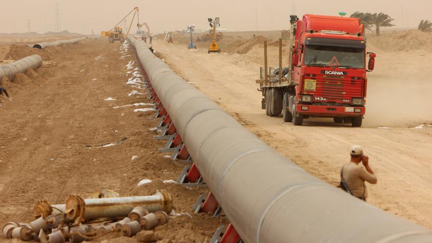 Workers set up a natural gas pipeline during a dust storm at Iraq's border with Iran in Basra, southeast of Baghdad, April 12, 2016.  REUTERS/Essam Al-Sudani - GF10000380312