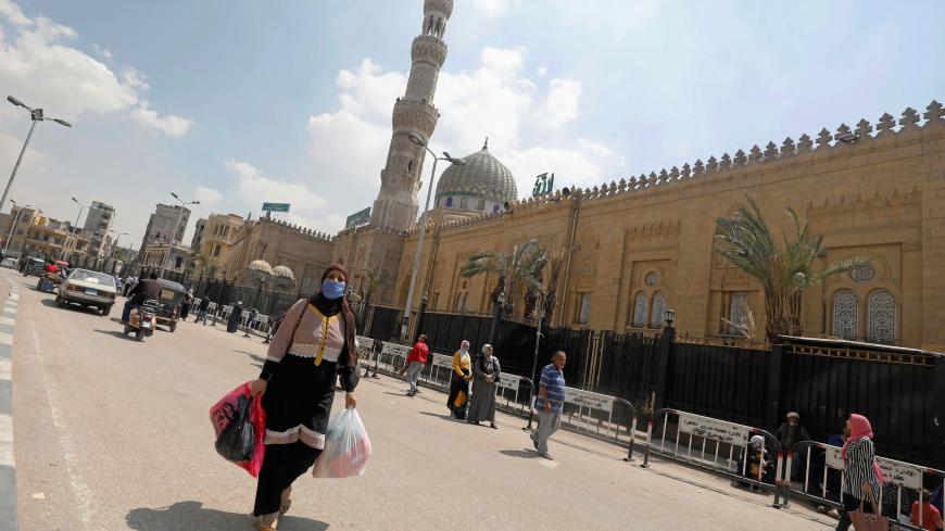 A woman wearing a face mask amid the coronavirus (COVID-19) walks in front of the closed Sayyida Zainab Mosque near markets that sell traditional lanterns in Cairo, Egypt, April 12, 2020. Picture taken April 12, 2020. REUTERS/Mohamed Abd El Ghany - RC2N8G9BNEVV