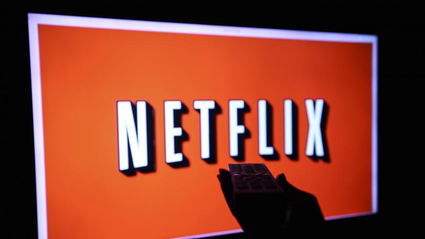 ANKARA, TURKEY - NOVEMBER 27:  A woman holds a remote control in front a TV screen displaying Netflix logo in Ankara, Turkey on November  27, 2018. (Photo by Ercin Top/Anadolu Agency/Getty Images)