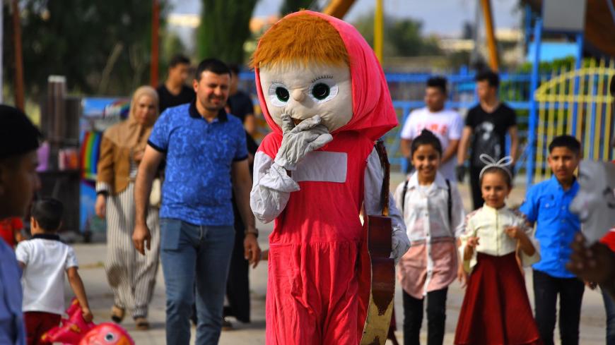 Iraqis walk at a luna park empty in the northern iraqi city of Mosul on May 25, 2020 on the second day of Eid al-Fitr, the Muslim holiday which starts at the conclusion of the holy fasting month of Ramadan, after months of closure due to the coronavirus Covid-19 lockdown. - Muslims around the world began marking a sombre Eid al-Fitr, many under coronavirus lockdown, but lax restrictions offered respite to worshippers in some countries despite fears of skyrocketing infections. (Photo by Zaid AL-OBEIDI / AFP)