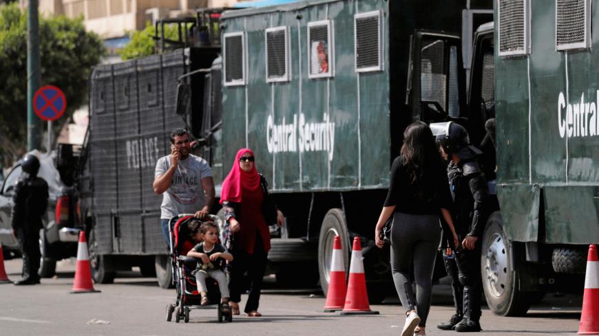 People walk in front of Egyptian riot police are seen on Tahrir square on the road to U.S. Embassy in Cairo, Egypt May 14, 2018. REUTERS/Amr Abdallah Dalsh - RC12866621B0