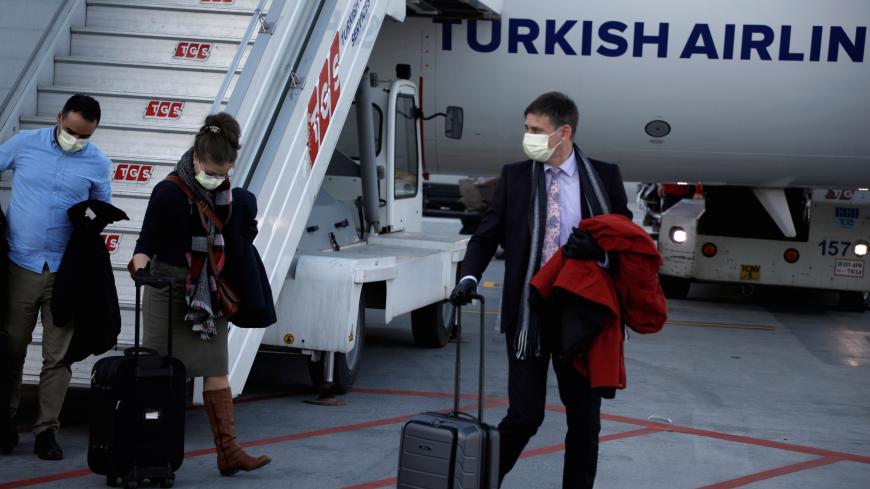 A passenger wears a protective face mask in light of the coronavirus, upon arrival at Istanbul Airport, Turkey, March 13, 2020. REUTERS/Florion Goga - RC28JF95WH9J