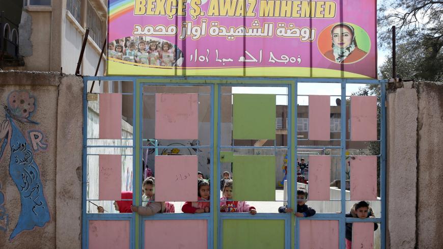 Kurdish children look through a gate at a pre-school in Qamishli, Syria, March 6, 2019. Picture taken March 6, 2019. REUTERS/Issam Abdallah - RC14F6F6D600