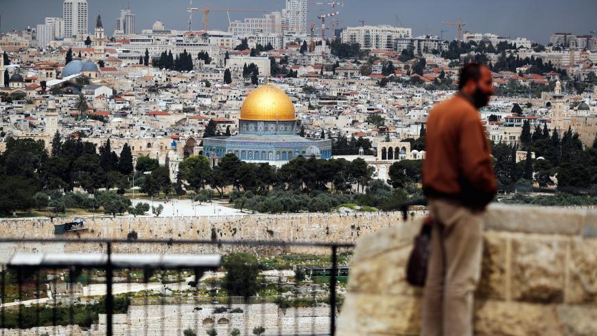 A man stands at a lookout site overlooking Jerusalem's Old City as Muslims mark the first Friday prayer of Ramadan amid the coronavirus disease (COVID-19) restrictions April 24, 2020 REUTERS/ Ammar Awad - RC20BG9OK9U5