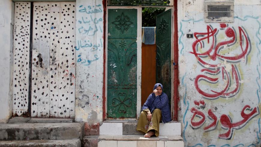 A Palestinian woman sits outside her home in Jabalia refugee camp, one of the most densely populated areas in the world, amid concerns about the spread of the coronavirus disease (COVID-19), in the northern Gaza Strip May 5, 2020. REUTERS/Mohammed Salem - RC2CIG93IB6K