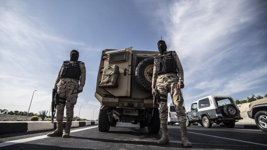 Egyptian soldiers stand guard during an organised tour for diplomats to mark the 150th anniversary of the inauguration of the Suez Canal, in the northeastern city of Ismailia on November 17, 2019. - One hundred and fifty years after the Suez Canal opened, the international waterway is hugely significant to the economy of modern-day Egypt, which nationalised it in 1956. The canal, dug in the 19th century using "rudimentary tools" and which links the Mediterranean to the Red Sea, was opened to navigation in 1