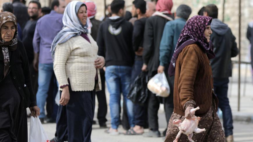 Women hold food aid distributed by humanitarian institutions in Afrin, Syria March 20, 2018. REUTERS/Khalil Ashawi - RC169F36FD00