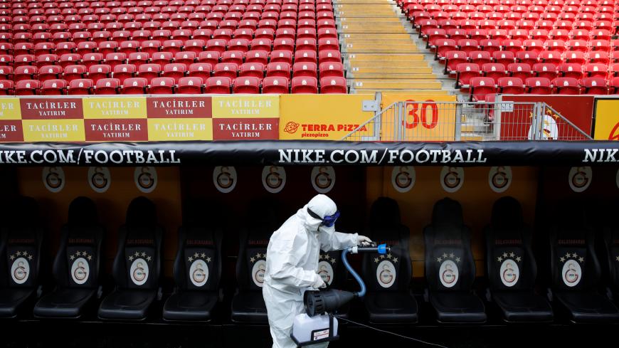 A worker in protective suit disinfects the Turk Telekom Stadium in Istanbul, Turkey March 14, 2020. REUTERS/Umit Bektas - RC2OJF9UV6LF