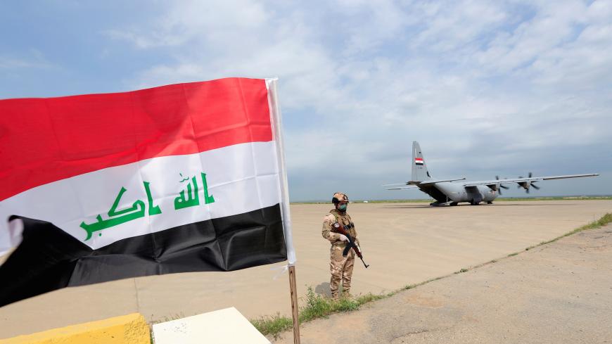An Iraqi soldier wears a protective face mask and gloves, following the outbreak of coronavirus disease (COVID-19), as he stands guard during the hand over of Qayyarah Airfield West from US-led coalition forces to Iraqi Security Forces, in the south of Mosul, Iraq March 26, 2020. REUTERS/Thaier Al-Sudani - RC2SRF9WTZ1K