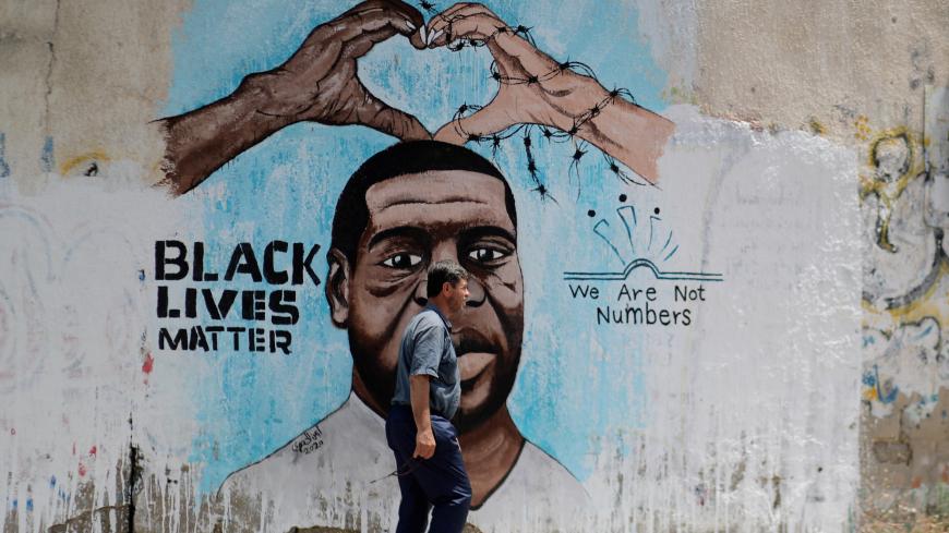 A Palestinian man walks past a mural depicting George Floyd, who died in Minneapolis police custody, in Gaza City June 18, 2020. REUTERS/Mohammed Salem - RC2PBH9PNMI4