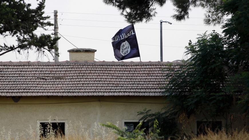 An Islamic State flag flies over the custom office of Syria's Jarablus border gate as it is pictured from the Turkish town of Karkamis, in Gaziantep province, Turkey August 1, 2015. Karkamis is a Turkish town of 10,500 people that sits directly opposite the border post. Shut for more than a year, the military sealed the crossing with a breeze block wall a few months ago. Behind it, just inside Syria, the black flag of Islamic State flaps in the breeze. Karkamis lies on the northeastern edge of a rectangle o