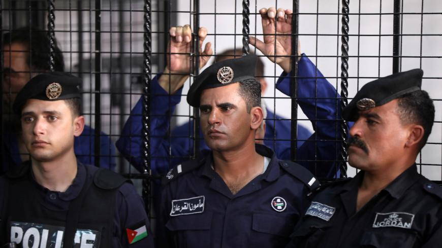 Police officers stand during trial held for over 30 businessmen and customs officials charged with millions of dollars in tax evasion, at the State Security Court, in Amman, Jordan March 12, 2019. REUTERS/Muhammad Hamed - RC179548DF80