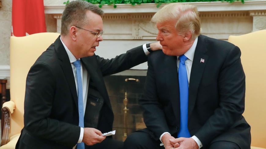 Freed American pastor Andrew Brunson (L) prays for US President Donald Trump at the White House in Washington, DC, October 13, 2018. - Brunson, held for two years in Turkey, returned to the US earlier Saturday after a court freed him in a case that sparked a crisis in Ankara's ties with Washington and trouble for its economy. The court in the western town of Aliaga convicted Brunson on terror-related charges and sentenced him to three years, one month and 15 days in jail. (Photo by ROBERTO SCHMIDT / AFP) (P