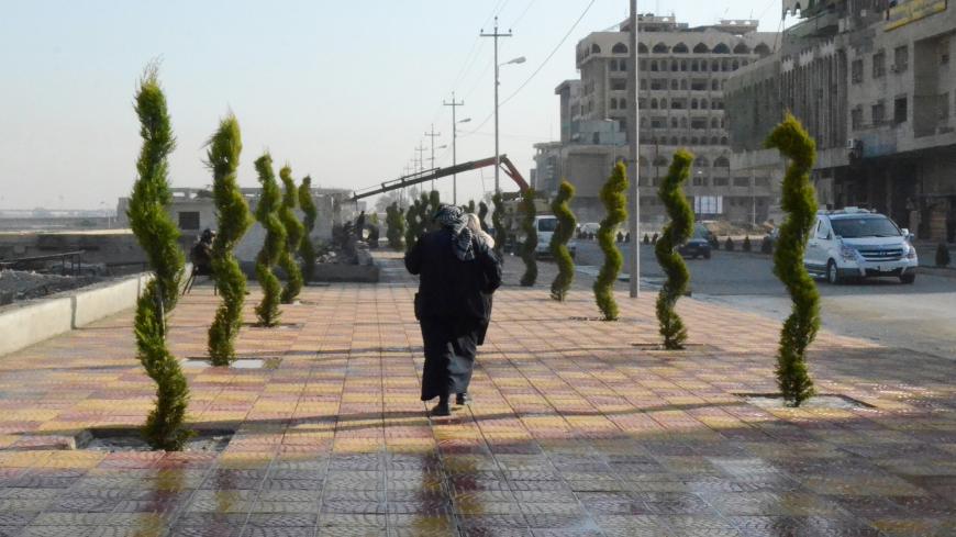 A woman walks in between newly planted trees in Iraq's northern city of Mosul, on January 23, 2019, as the war-ravaged city gets a facelift following three years of brutal rule by the Islamic State group. (Photo by Zaid AL-OBEIDI / AFP)        (Photo credit should read ZAID AL-OBEIDI/AFP via Getty Images)